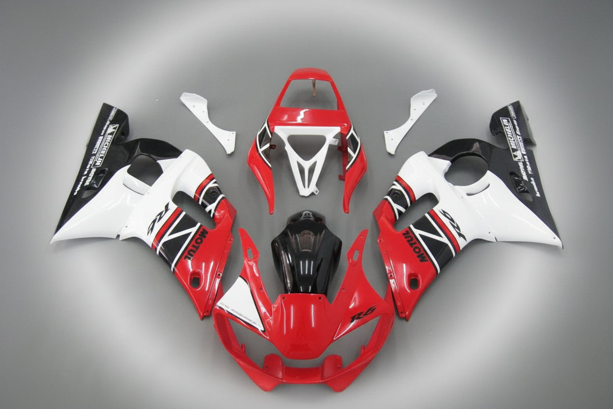 Motorcycle bodywork pieces in red, white, and black on a gray background