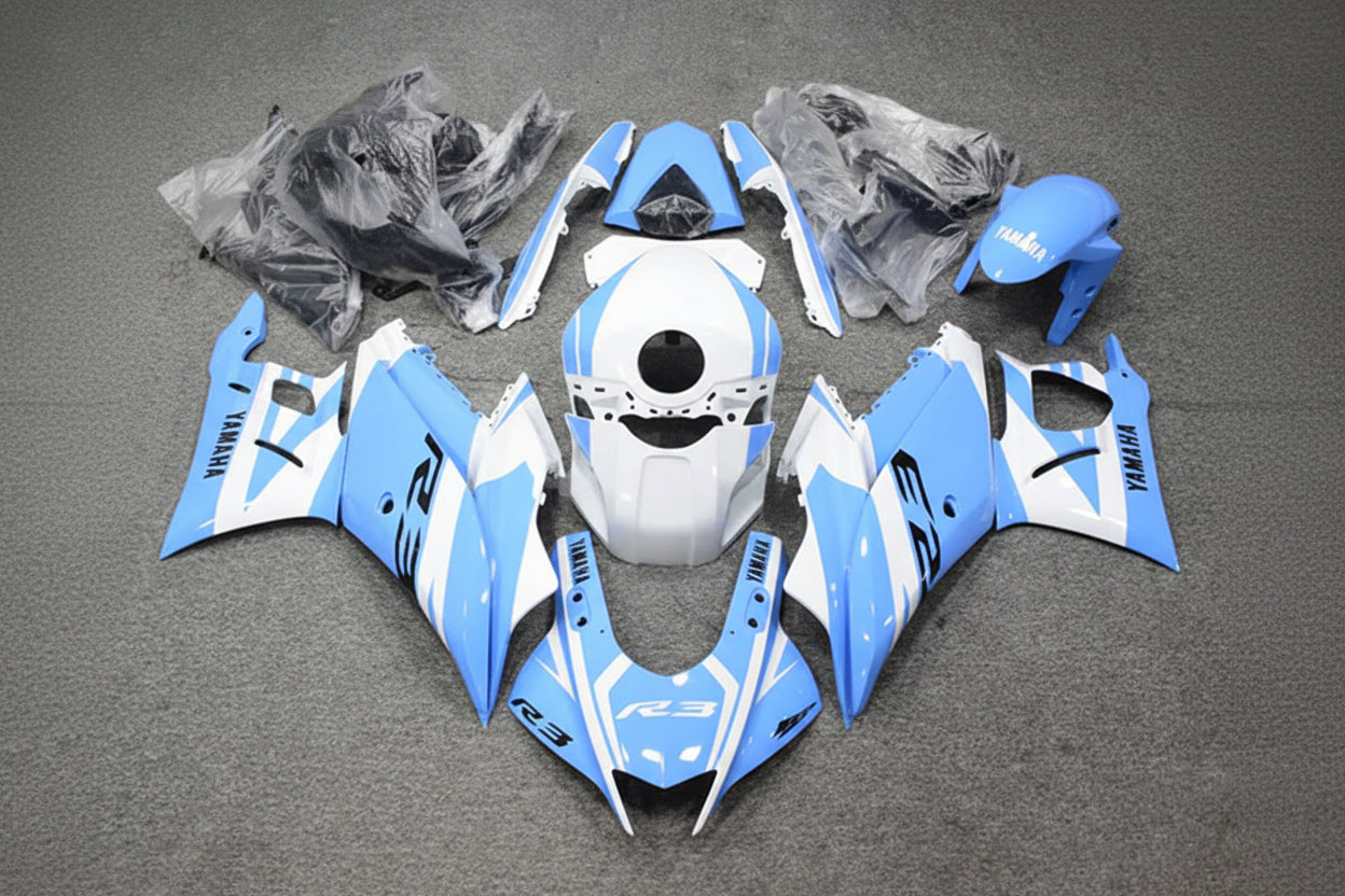 Motorcycle bodywork pieces in blue and white on a gray surface
