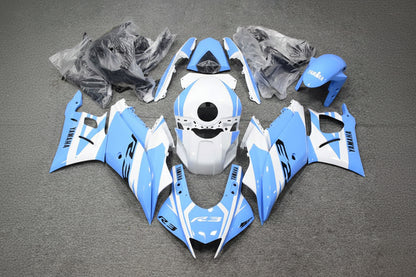 Motorcycle bodywork pieces in blue and white on a gray surface