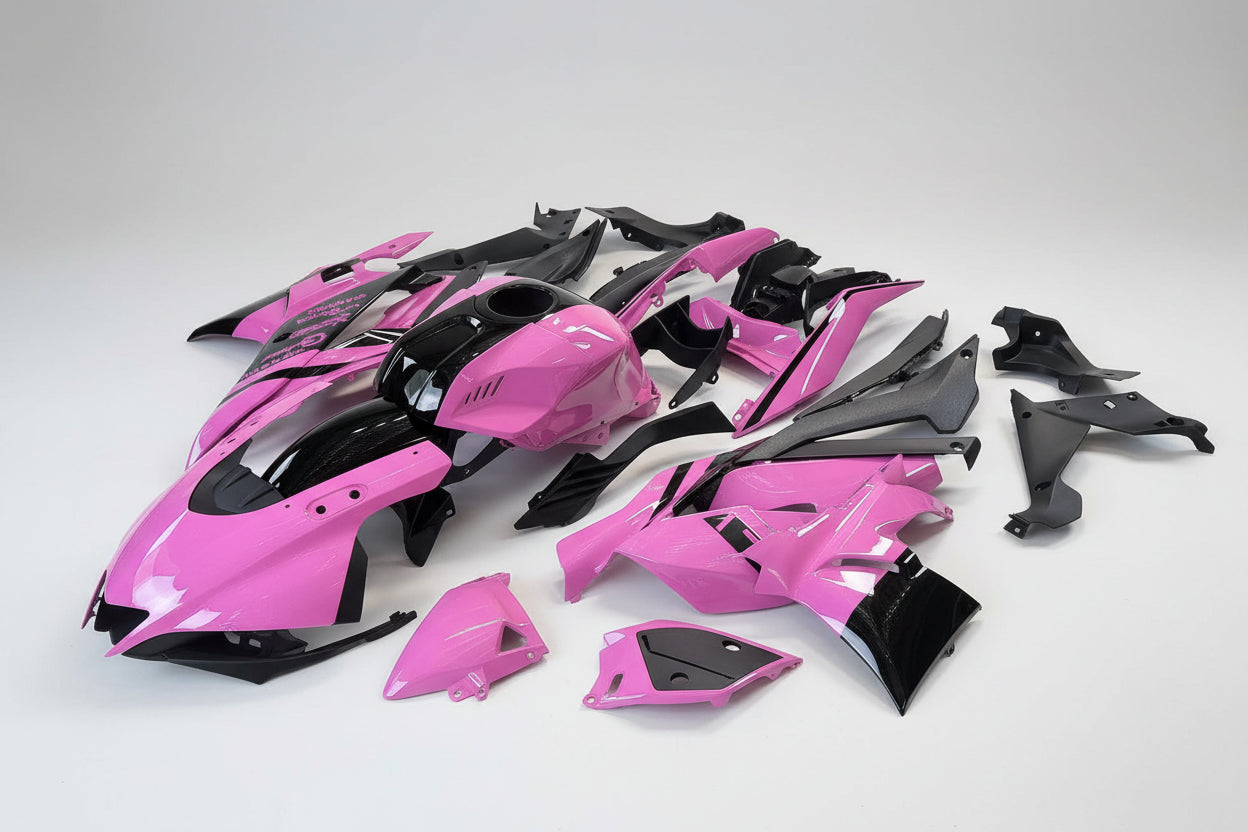 Pink and black motorcycle body parts on a white background