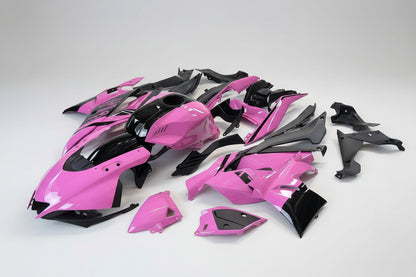 Pink and black motorcycle body parts on a white background