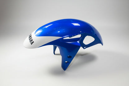 Blue motorcycle fairing with white accents on a white background