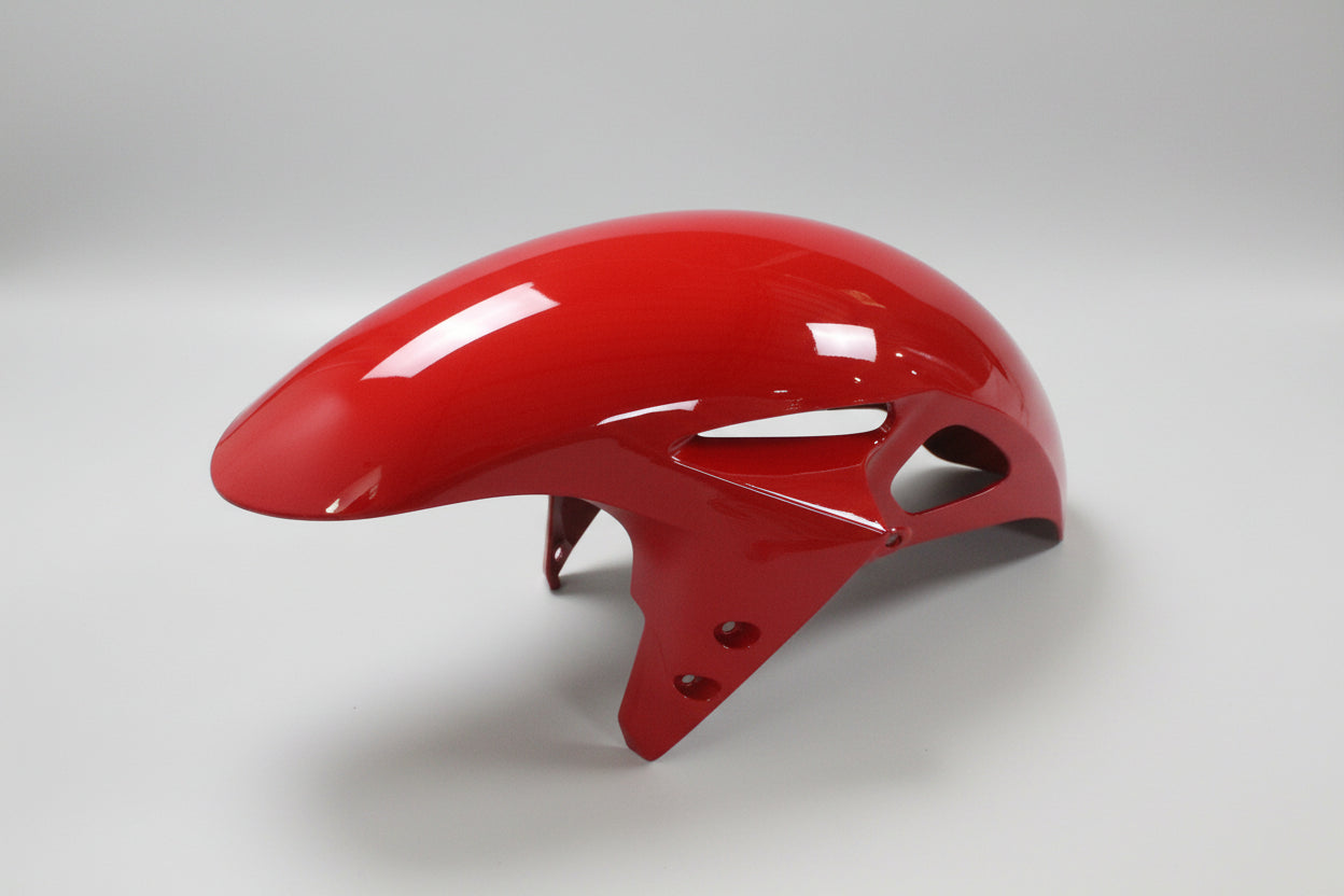 Glossy red motorcycle fender on a white background