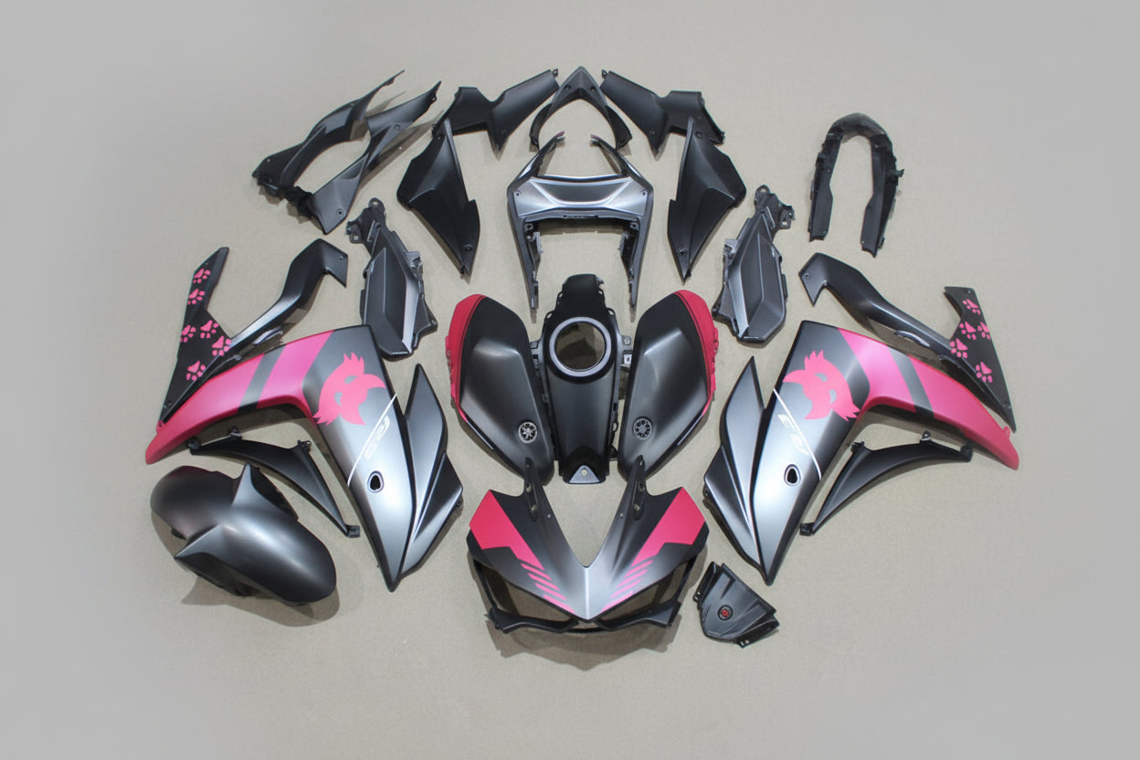 Motorcycle body parts with pink and black design on a beige background